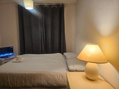 a bedroom with a bed and a lamp on a table at Happy Lodge Gillingam Kent in Gillingham