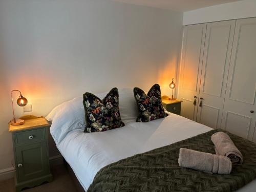 a bedroom with a bed with pillows and two lamps at May Townhouse in Ulverston