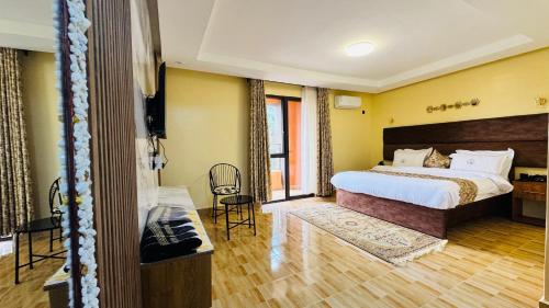 a hotel room with a bed and a television in it at Alya Hotel & Suites Ltd in Nairobi