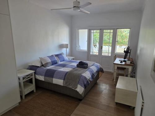 a bedroom with a bed and a desk and a window at Jonker's Cottage in Malgas