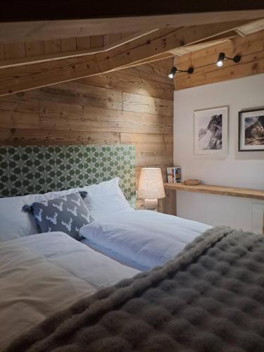 a bedroom with a bed with a wooden wall at Alpen Lodge Premium Apartment in Mezzana