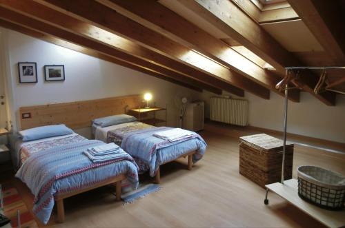 a attic room with two beds and a table at B&B Leon d'Oro in Pusiano