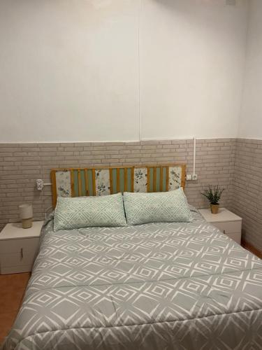 a bedroom with a bed with a gray comforter at Clau al castell apartament in Serra