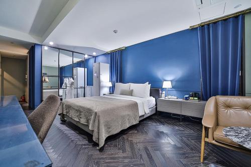 a bedroom with a large bed and a blue wall at js 부티크 호텔 동탄 in Hwaseong