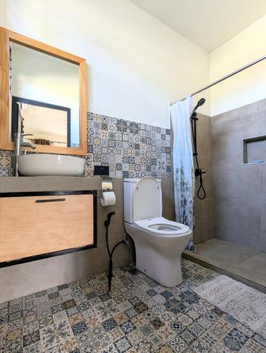 a bathroom with a toilet and a sink and a shower at Jabali in Roches Noires