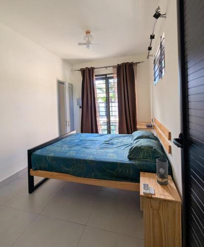 a bedroom with a bed and a table and a window at Jabali in Roches Noires
