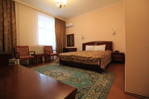 a hotel room with a bed and a table at Алма Ата in Borovoye