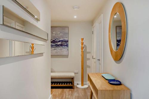 a living room with a wooden table and a mirror at 2 Bed in Padstow oc-28108 in Padstow