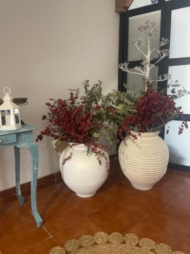 two white vases with plants in them next to a table at Apartamento Casa Nela in Medellín