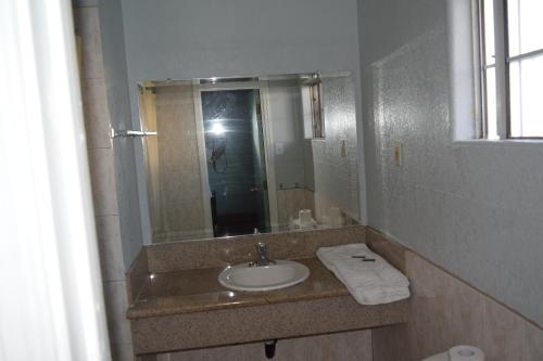 y baño con lavabo y espejo. en Top Hat Motel, en Los Ángeles