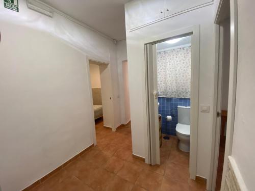 a bathroom with a toilet and a door to a room at Clau al castell apartament in Serra