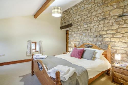 a bedroom with a bed with a stone wall at 3 Bed in Ingleton oc-l34471 in Ingleton