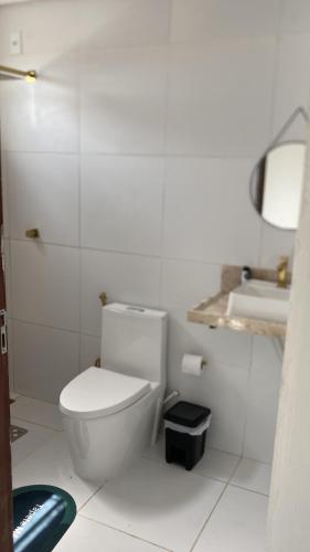 a white bathroom with a toilet and a sink at Casa em clube in São José de Ribamar