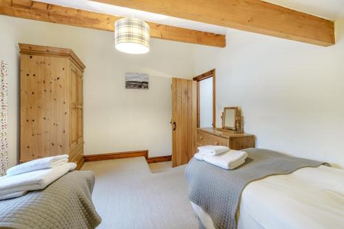 two beds in a room with wooden ceilings at 2 Bed in Ingleton oc-h34470 in Ingleton