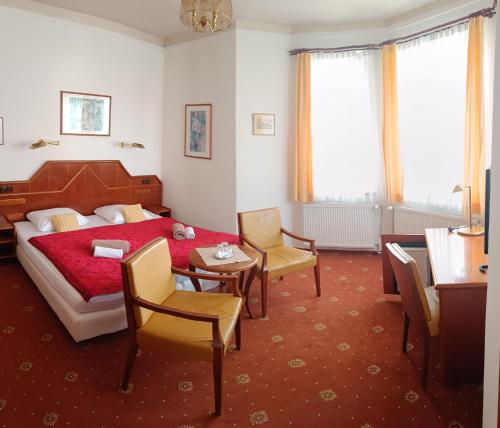 a bedroom with a bed and a table and chairs at Pension Josef in Františkovy Lázně