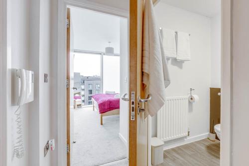 a bathroom with a door open to a room at Ruby City Stay Apartment CMK Free Parking in Milton Keynes