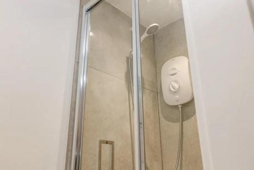 a shower in a bathroom with a soap dispenser at 1885 The Retreat in Matlock