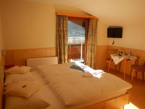 a bedroom with two twin beds and a window at Frühstückspension TROGER in Sankt Jakob in Defereggen