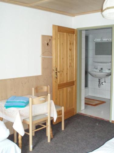 a room with a bathroom with a sink and a table at Frühstückspension TROGER in Sankt Jakob in Defereggen