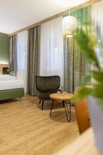 a room with a bed and a chair and a table at StadlTraum Falkenberg in Moosach