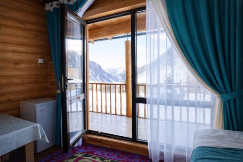 a bedroom with a window with a view of a balcony at Мурас Эко - Ресорт in Alamedin
