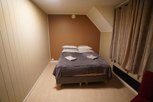 a bedroom with a bed with towels on it at Cherry Rooms in Tromsø