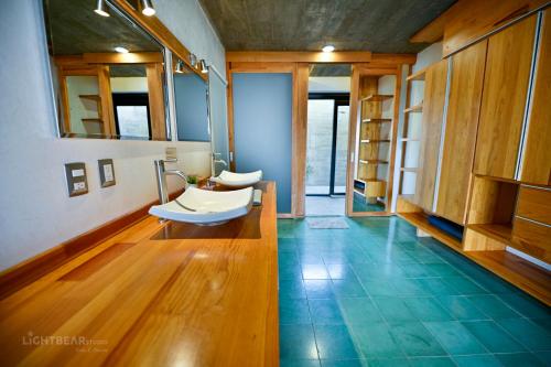 a bathroom with a tub and a sink on a wooden floor at Utopia Casas Boutique in Oaxaca City