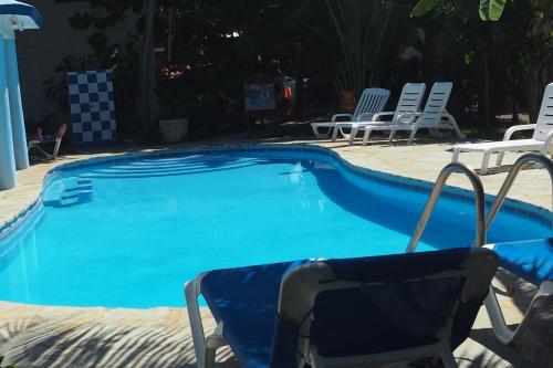 a blue swimming pool with chairs and a table at Residencial Estephany in Sosúa