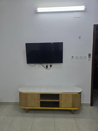 a flat screen tv on a wall with a coffee table at شقق عبدالله in Al-ʿUla