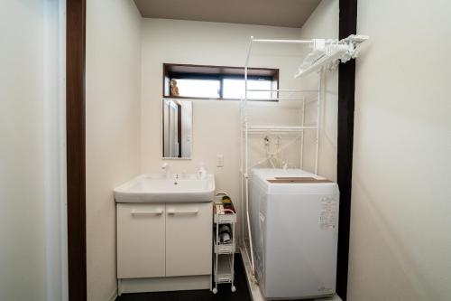 a white bathroom with a sink and a mirror at 三十三Kumo in Kyoto