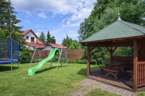 a playground with a green slide and a gazebo at Kalipso nad Jeziorem Białym in Okuninka