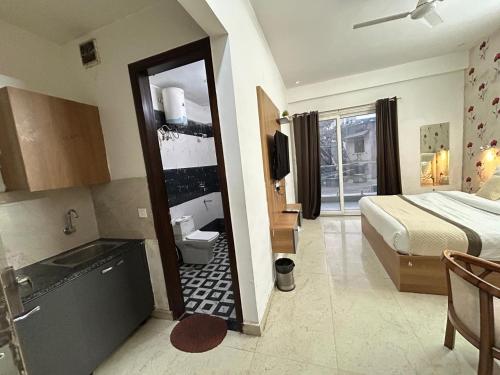 a hotel room with a bed and a mirror at The Grand Hotel Akshay in Gurgaon
