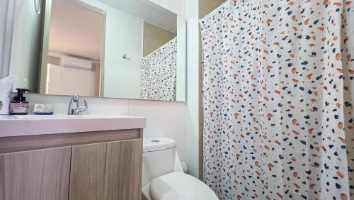 a bathroom with a toilet and a sink and a shower at Capriella, Serena Del Mar in Cartagena de Indias