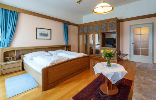 ein Schlafzimmer mit einem Bett und einer Blumenvase auf einem Tisch in der Unterkunft Altstadthotel Eck in Lienz