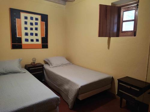 a small room with two beds and a window at Costas Guests in Sardoal