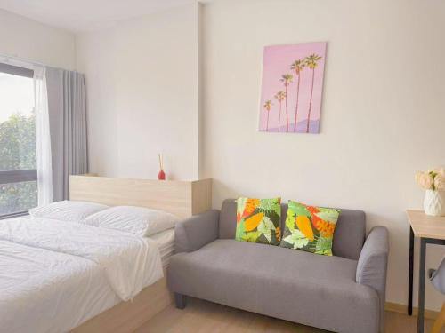 a bedroom with a bed and a couch and a chair at Vay 1 Pattaya Downtown Cozy Condo in North Pattaya
