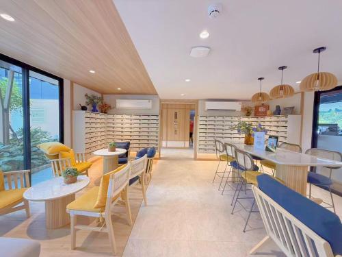a restaurant with tables and chairs and windows at Vay 1 Pattaya Downtown Cozy Condo in North Pattaya