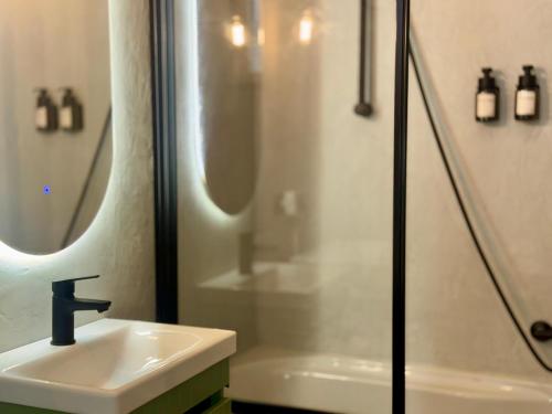 a bathroom with a sink and a shower at Vespa Azzurra Boutique Apartment - Free Parking in Acquaseria