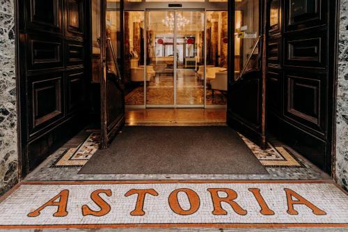 a entrance to a store with a sign on the floor at Hotel Astoria in Turin