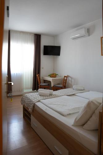 a bedroom with a large bed and a table at Apartmani Roić in Gradac