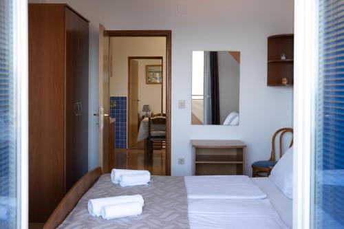 a bedroom with a bed with two towels on it at Apartmani Roić in Gradac