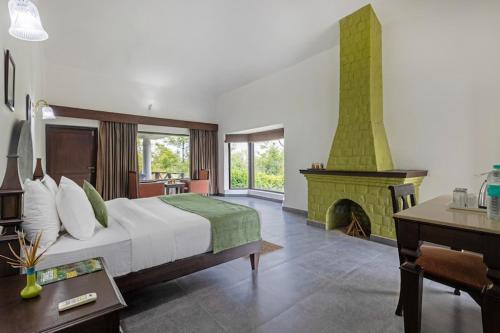 a bedroom with a large bed and a fireplace at VANVASA RESORTs in Kānda