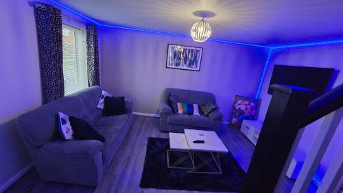 a purple living room with a couch and a table at Entire 3 bedroom luxurious house, Wigan , Manchester in Wigan
