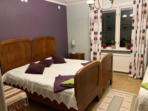 a bedroom with a bed with purple walls and a window at Large family housing in Mariannelund