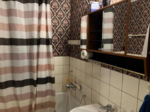 a bathroom with a sink and a shower curtain at Large family housing in Mariannelund