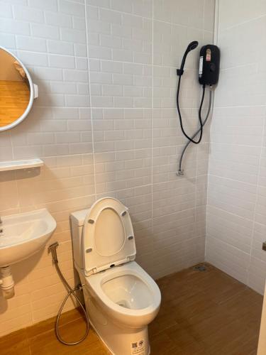 a bathroom with a toilet and a phone on the wall at บ้านสุดซอย-Baan Sud Soi in Prachuap Khiri Khan