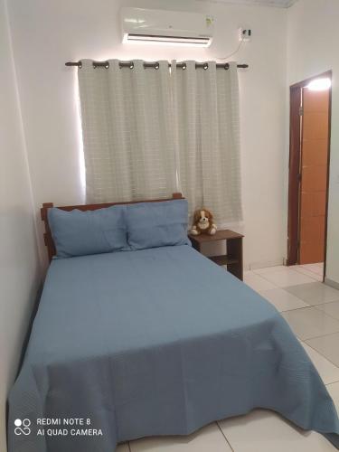 a bedroom with a blue bed and a window at casa Beija Flor in Riachão