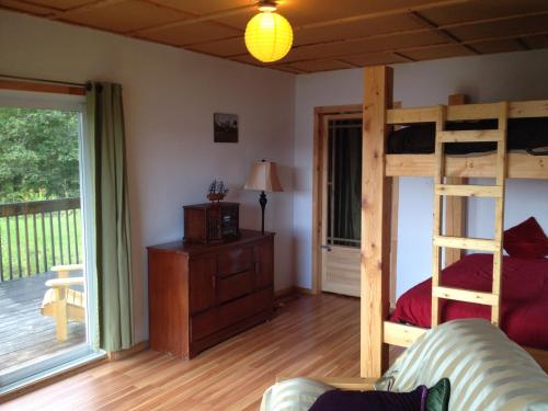 1 Schlafzimmer mit 2 Etagenbetten und einem Sofa in der Unterkunft Villa de la Montagne in Sainte-Rose-du-Nord