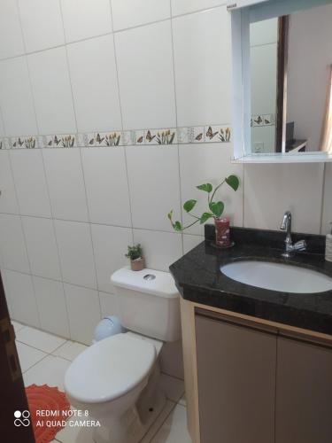 a bathroom with a toilet and a sink and a mirror at casa Beija Flor in Riachão