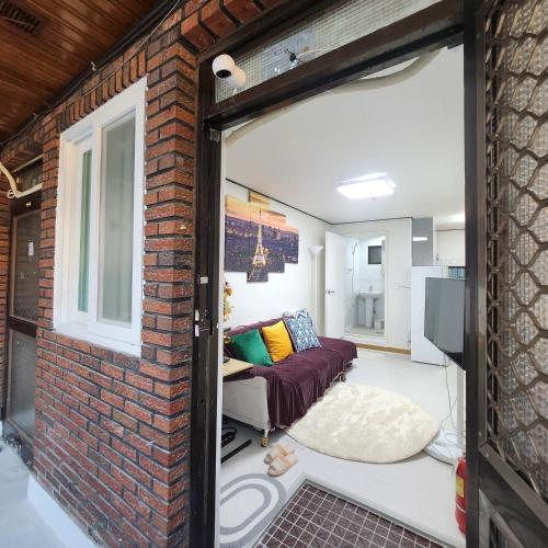 an open door into a living room with a brick wall at Sillim's Rest Area in Seoul